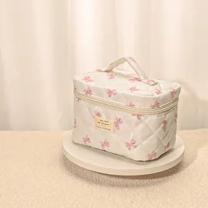 Quilted cosmetic bag with cute pink bow pattern, large capacity portable makeup pouch for travel.