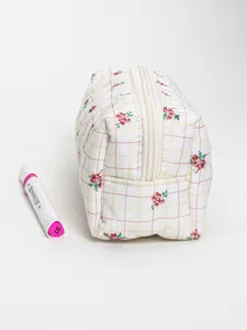 Quilted floral cosmetic bag, fabric storage pouch with zipper closure, detailed view.