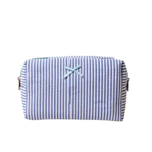 Blue and white striped cosmetic bag detail featuring a cute bow and secure zipper closure.