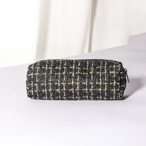 Black tweed cosmetic pouch detail view, showcasing the exquisite textured fabric and zipper.