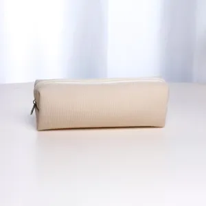 Minimalist beige corduroy fabric texture detail of portable travel makeup brush pouch