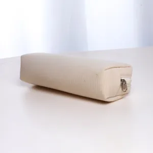 Beige corduroy cosmetic pouch detail view, soft textured fabric with a smooth metal zipper.
