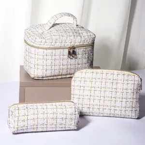 Detailed view of the white tweed cosmetic bag set, featuring elegant gold thread texture and durable zippers.