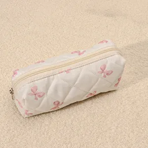 Quilted cosmetic bag detail view showing soft pink bow print and smooth zipper closure.