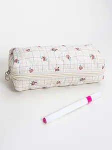 Quilted floral cosmetic bag detail view showing fine stitching, zipper and grid pattern fabric.