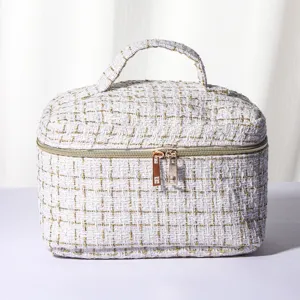 White gold tweed cosmetic bag with top handle, portable travel makeup storage pouch view.