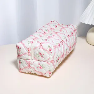 Quilted floral ribbon storage bag detail, spacious cosmetic and hair tool organizer pouch.