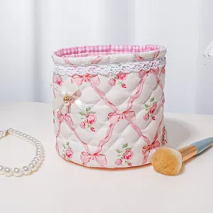 Chic quilted cylindrical storage basket detail, pink floral design with cute bow and lace trim.