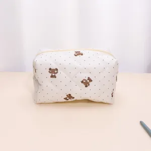 Close-up detail of the quilted cosmetic pouch featuring cute brown bear prints and soft padding.
