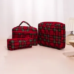 Detailed shot of red green plaid quilted cosmetic bags set, elegant travel storage bags.