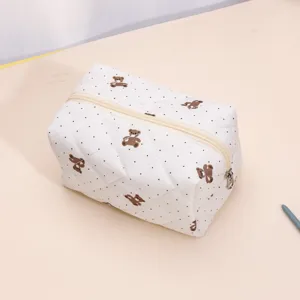 Quilted cosmetic bag detail featuring cute bear and polka dot pattern with smooth zipper.
