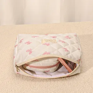 Quilted makeup bag with cute pink bow pattern, large capacity travel cosmetic storage pouch.