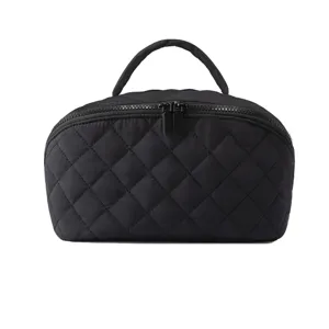 Détail trousse de maquillage noire matelassée, pochette cosmétique douce avec double zip.