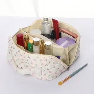Détail de la trousse de maquillage matelassée aux cerises avec compartiments de rangement.