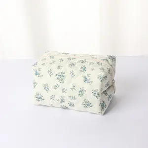 Close-up detail of quilted floral makeup bag with neat stitching and smooth zipper closure.