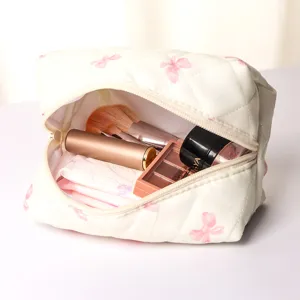 Detailed view of the quilted makeup pouch interior, showing spacious storage for cosmetics.
