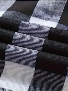Detailed close-up view of black and white plaid flannel fabric texture and folds.