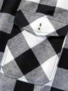 Close up view of black and white plaid flannel shirt chest pocket and button detail texture.