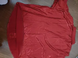 Détail de chemise à manches longues métalliques rouges, gros plan style disco rétro.