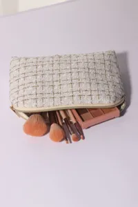 Portable tweed cosmetic bag with large capacity, chic travel makeup pouch and brushes set.