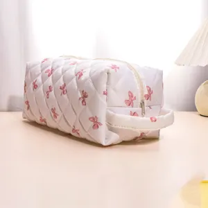 Quilted floral cosmetic bag with bow pattern, portable travel storage pouch for hair dryer.
