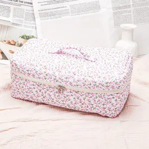 Quilted floral cosmetic bag with zipper and handle, perfect for travel storage and daily use.