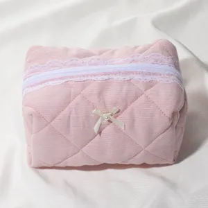 Pink waffle cosmetic bag with lace and cute bow zipper pouch for travel makeup storage.