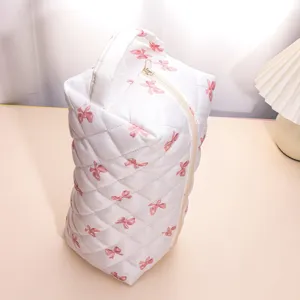 Closeup detail of the quilted cosmetic bag with pink bow pattern and durable zipper opening.