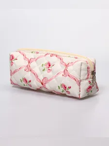 Deliziosa borsa cosmetica trapuntata con motivo floreale rosa e nastro, custodia morbida.