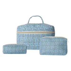 Tweed cosmetic bag set detail view featuring textured blue travel makeup storage organizer.