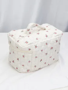 Quilted floral cosmetic bag, portable travel makeup storage organizer with zipper and handle.