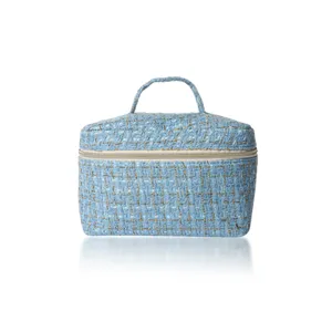 Blue tweed cosmetic bag detail showing textured fabric and sturdy zipper closure.