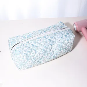 Quilted blue floral storage bag detail view, soft padded portable organizer for styling tools.