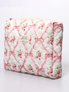 Quilted cosmetic pouch detail featuring a charming pink rose and ribbon print with a cute fabric label.