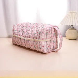 Close-up detail of the pink floral quilted travel storage bag, showing fine stitching.