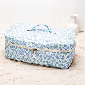 Quilted floral cosmetic bag detail, portable storage case with handle for hair tools and makeup.