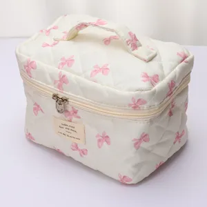 Quilted bow makeup bag with handle, cute portable cosmetic storage pouch for daily travel use.