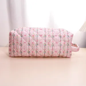 Pink floral quilted travel cosmetic bag with a side handle for easy hair tool storage.