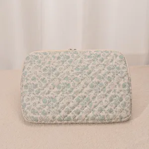 Nahaufnahme der gesteppten Blumen-Laptoptasche mit weicher Polsterung und Stoffdetails.