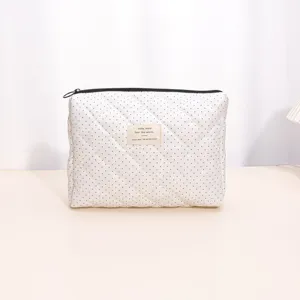 White quilted polka dot cosmetic bag with zipper, portable makeup pouch for daily use.