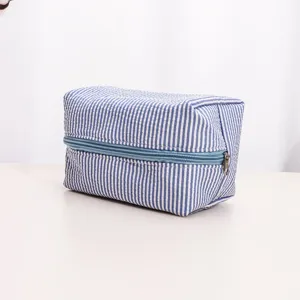 Blue and white striped toiletry bag detail, fabric cosmetic pouch zipper closure travel storage.
