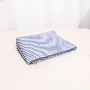 Detail view of blue white striped cosmetic pouch featuring durable zipper and portable use.