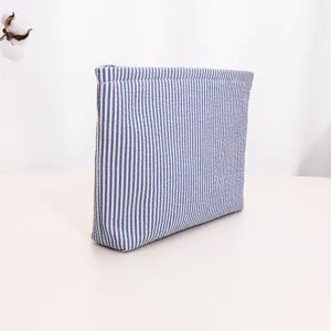 Blue and white striped fabric detail, closeup of zippered makeup bag texture and neat stitching.