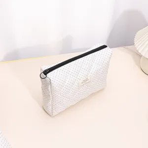 White quilted cosmetic bag with black polka dots, soft portable zipper storage pouch for travel.