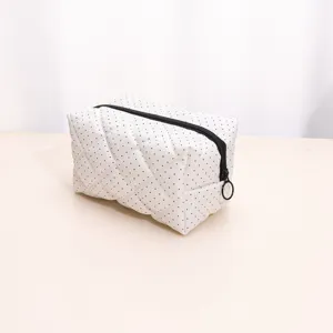White polka dot quilted makeup bag, soft padded cosmetic pouch with black zipper ring pull.