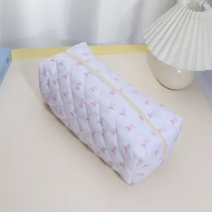Quilted cosmetic storage bag with cute pink bow pattern, portable zipper pouch organizer.