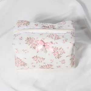 Quilted floral cosmetic bag with lace trim, cute bow and zipper for daily travel use.