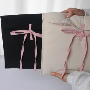 Quilted laptop sleeve detail showcasing soft padded fabric and cute pink bow ribbon tie.