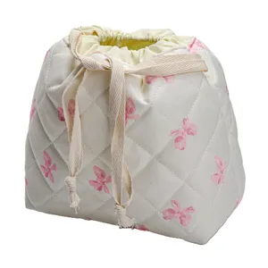 Quilted makeup pouch with pink bow print, spacious drawstring travel toiletry bag.
