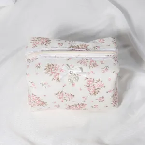 Quilted floral cosmetic bag with cute white lace trim and bow, portable makeup storage pouch.